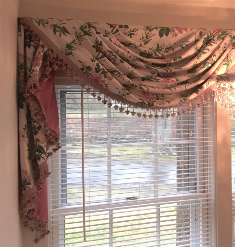 Flower patterned fabric drape with fringe over window