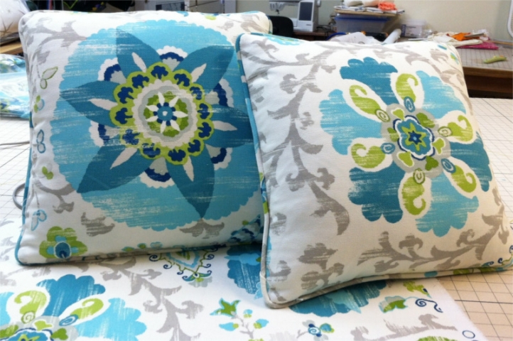 Square pillows of flower and leaf pattern with fabric piping