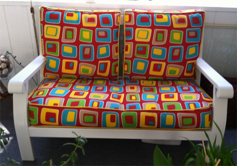 Colorful geometric patterned cushions on porch furniture love seat