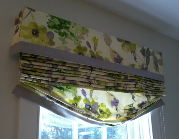 Roman shades with covered fabric top box, fabric is white background with large realistic yellow and purple flowers