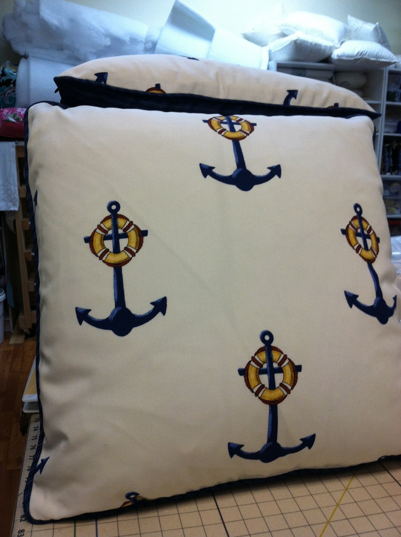 Anchor pattern on throw pillow with navy blue corded piping