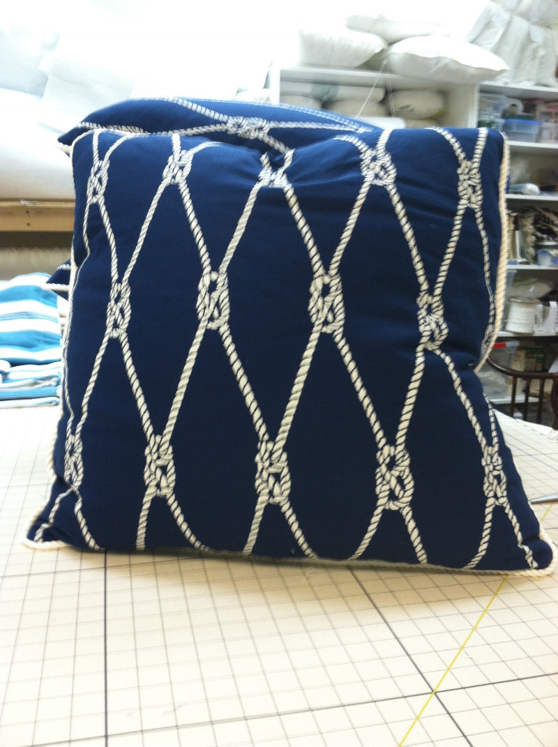 Patterned throw pillow with solid white cord piping