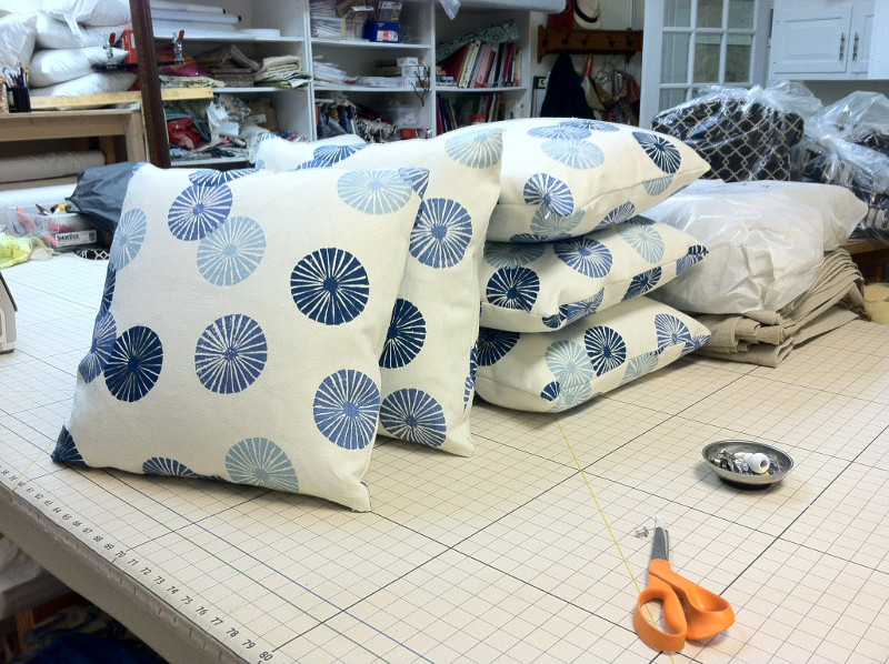 Five matching throw pillows on work table