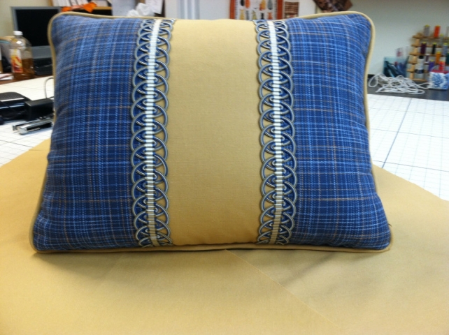 Throw pillow with decorative braid and piped edging