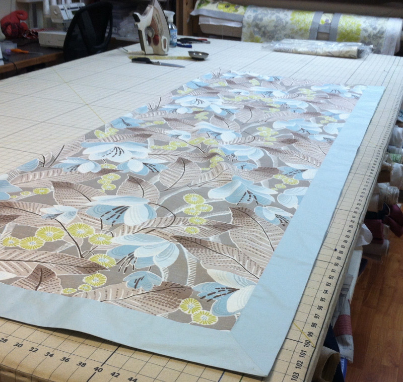 On the work table, fitting fabrics together for the perfect drapes