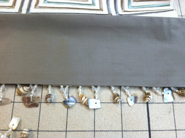 Closeup of hanging shell fringe on valance curtain