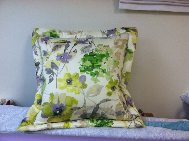 Throw pillow with deep stitched edging and inset piping of a flower pattern