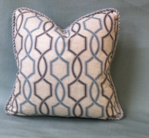 Throw pillow with rolled piped edging and geometric pattern