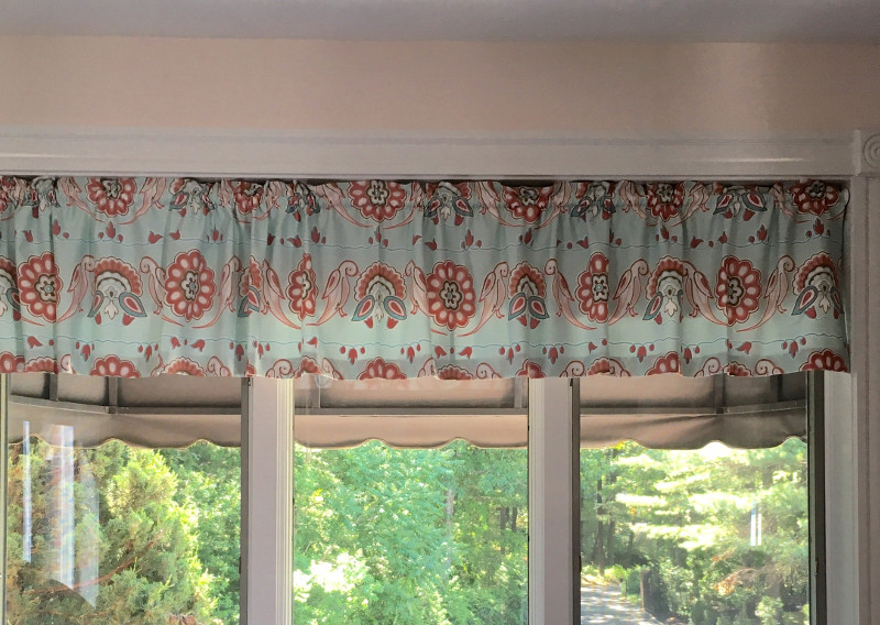 Valance drape with vertical pleats hanging on window