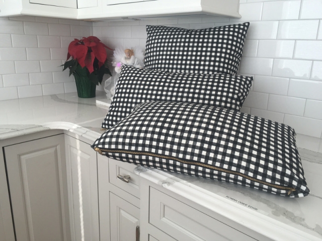 Three black and white checked throw pillows with zippers for easy case removal