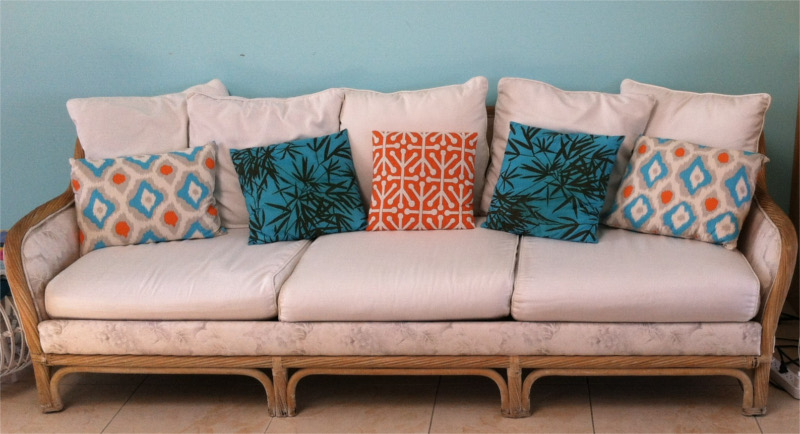 Custom couch cover, cushions, and throw pillows of hand-sewn fabrics in varying colors