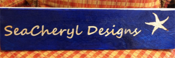 Sea Cheryl Designs wood carving with navy blue wood and sea star logo beside name
